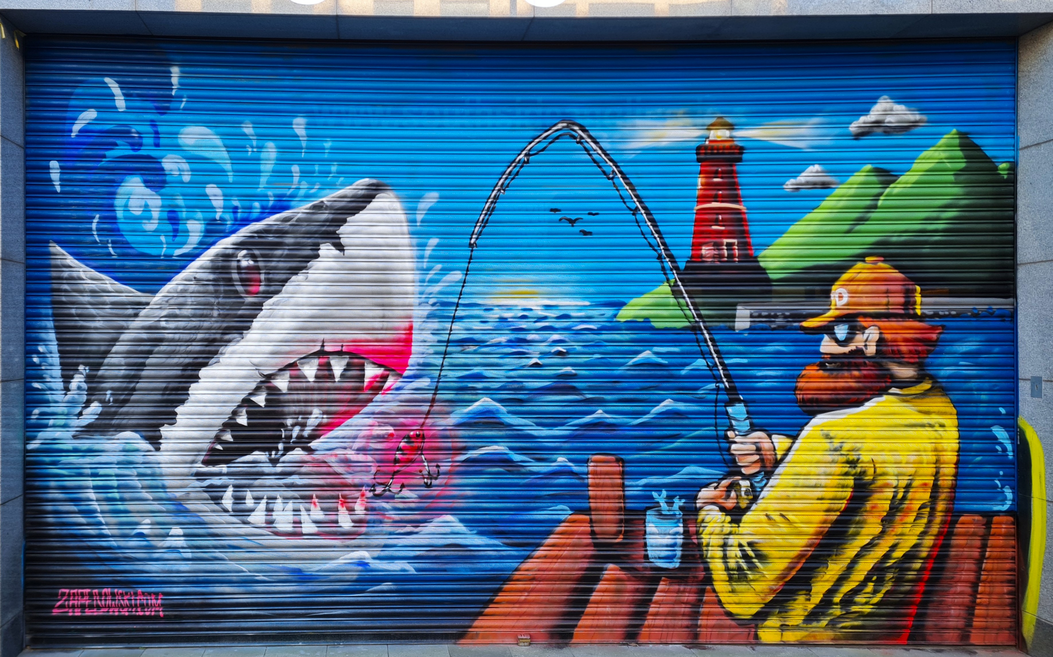 Realistic river and lake fishing scene mural painted on a Dublin shop wall by ZAP Art